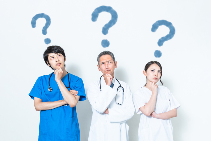 Medical doctor and nurses with question marks above heads.